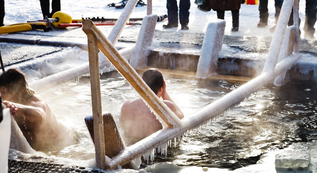 Man bathing in a hole in the ice